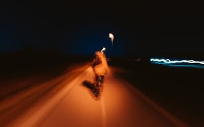 A man riding a skateboard down a street at night