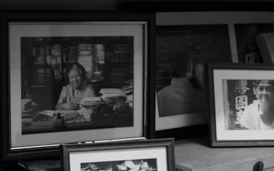 Framed black and white portraits on a shelf