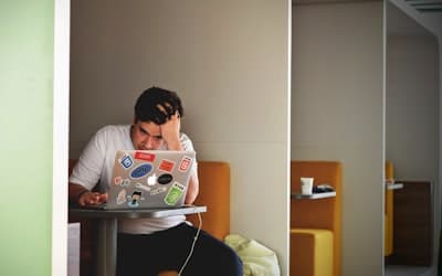 Man wearing white top using MacBook