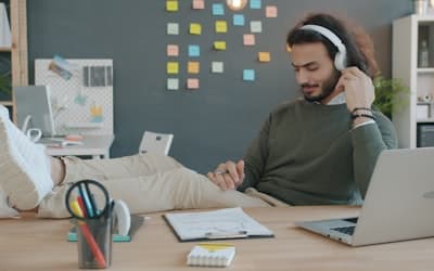 Man with headphones listening to music at desk